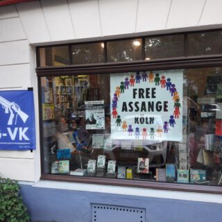 Scaufenster des anderen Buchladens, mit Free Assange Köln Plakat