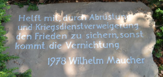 Ein heller Sandstein mit weißer Inschrift.