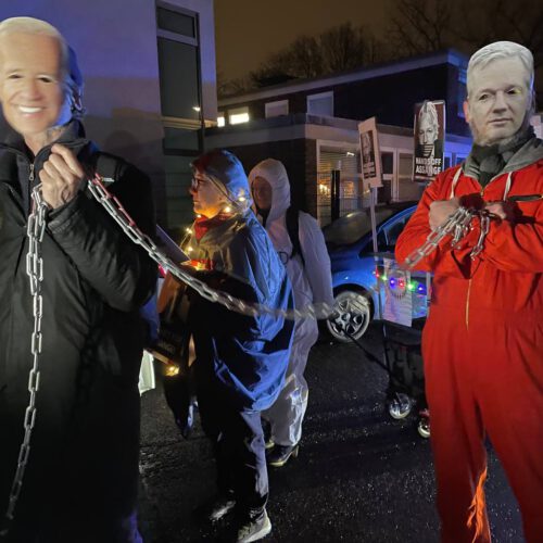 Szene in nächtlich beleuchteter Straße mit mehreren Leuten.