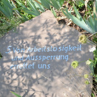 Ein heller Sandstein mit weißer Inschrift.