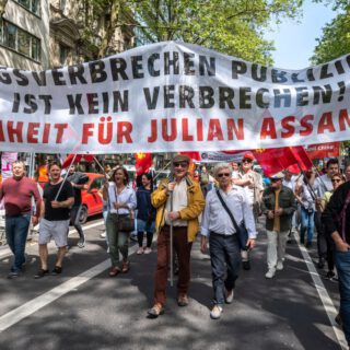 Transparent der Gruppe "Free Julian Assange" bei der 1. Mai-Kundgebung 2024 in Köln