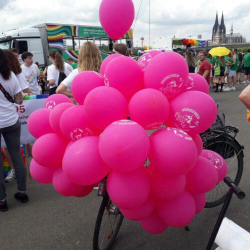 Eine große Menge pinker Luftballons verdeckt das Fahrrad, auf dem sie befestigt ist.