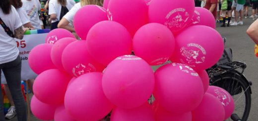 Eine große Menge pinker Luftballons verdeckt das Fahrrad, auf dem sie befestigt ist.